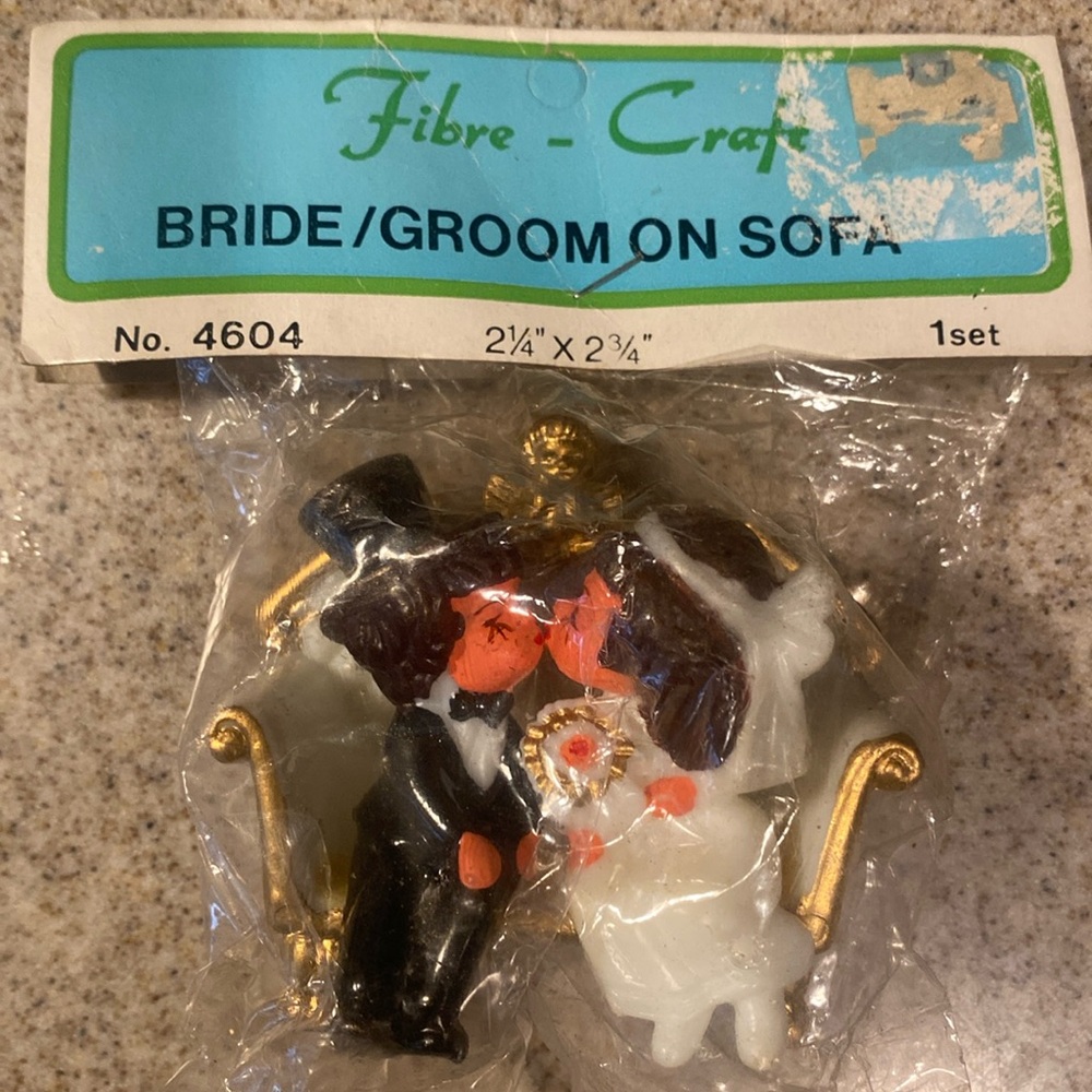 Vintage brunette bride & groom w/ top hat sitting on white sofa with gold trim